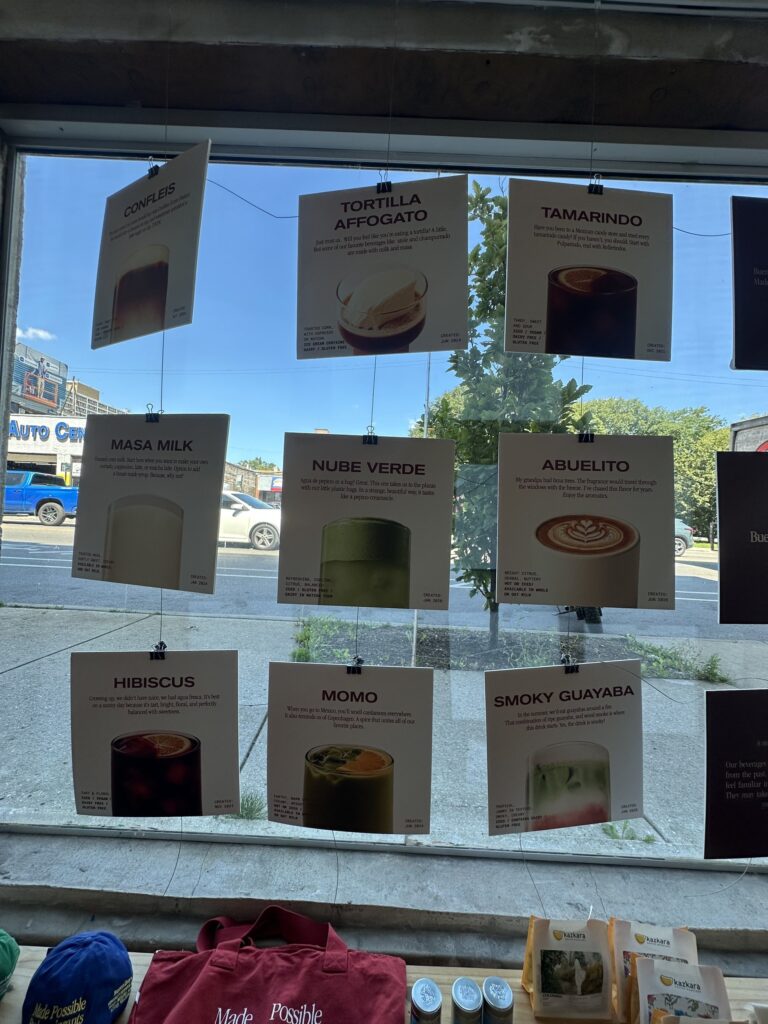 Nine drink cards strung in the BuenoDays front window, each with a created date