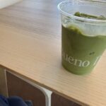 Iced masa matcha in a BuenoDays-branded cup on a wooden table