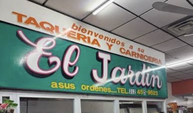 The Taqueria y Carniceria El Jardin sign, green with pink script lettering